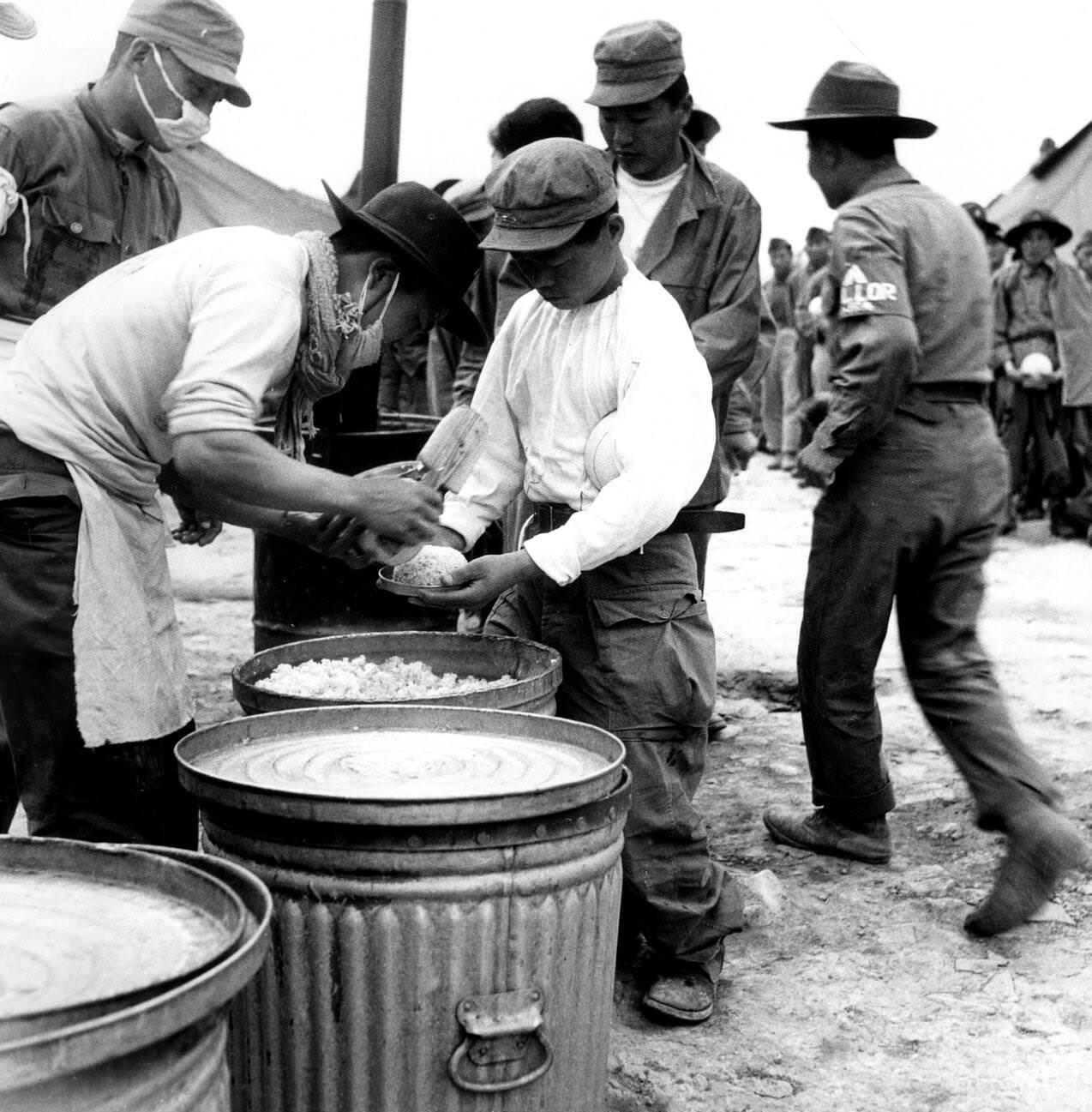 People are given rice in a U.N. camp during the Korean War, 1951.