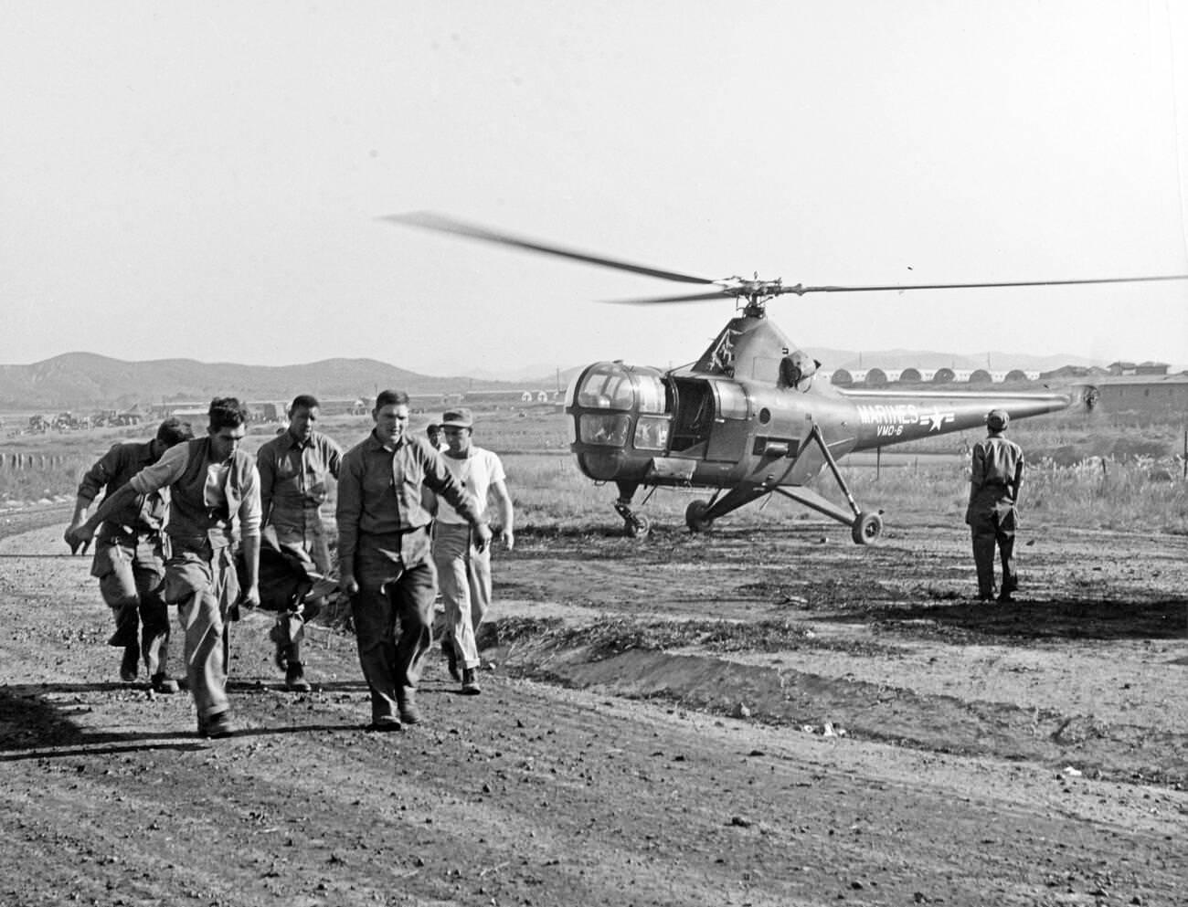 Korean War Casualty Evacuation. Navy Corpsmen help carry a wounded man, 1950s.