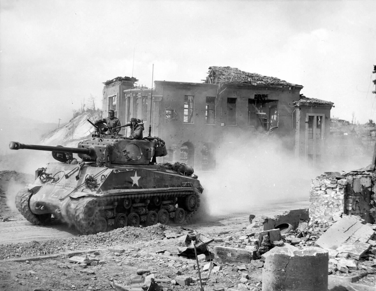 An American First Division tank drives north through Chuncheon, South Korea, 1951.