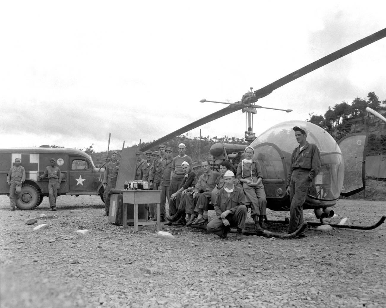 U.S. Army doctors and crew pose in front of a Bell helicopter, 1951.