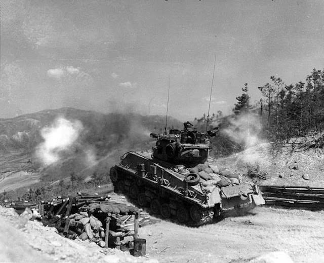 A Sherman tank fires its 76 mm gun at KPA bunkers, 1952.