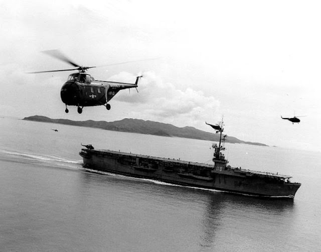 A US Navy Sikorsky HO4S flying near the USS Sicily, 1950s.