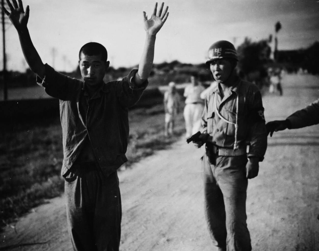 A South Korean military policeman marches a North Korean prisoner of war, 1950.