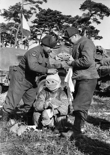 Turkish soldiers attend to a wounded prisoner, 1951.