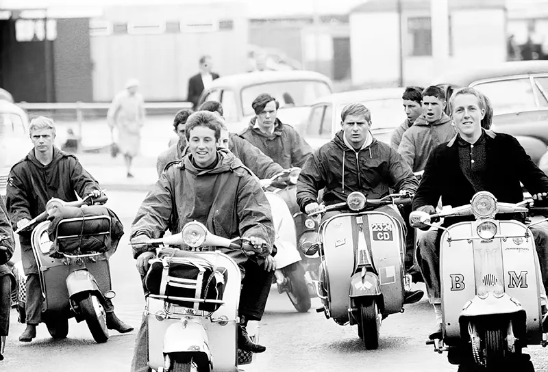 Mods on scooters ride down the streets of Hastings, England, 1964.