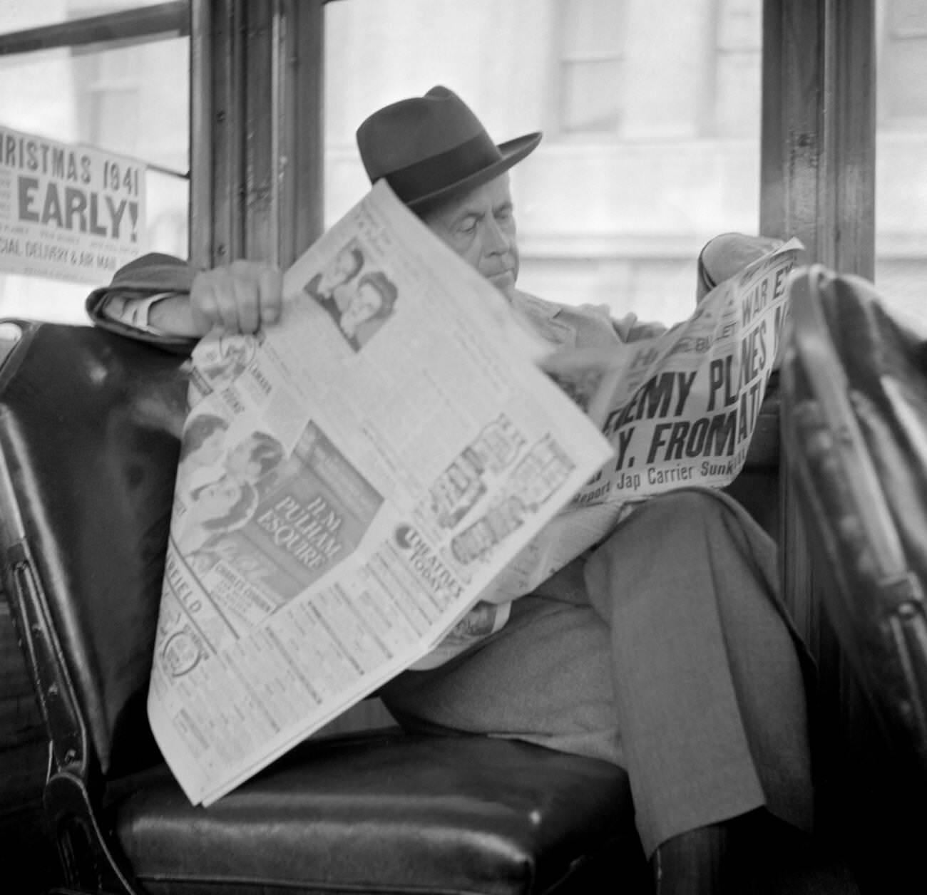 Man reading a newspaper on a bus, San Francisco, California, USA, 1941.