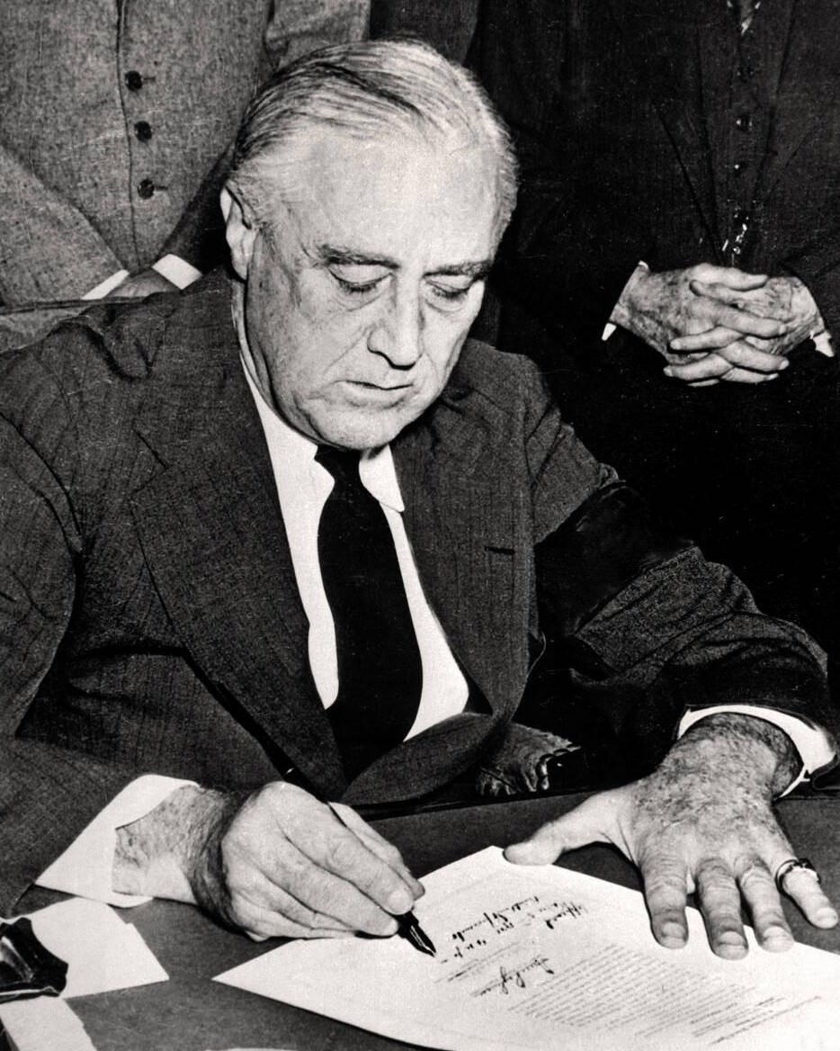 President Franklin D. Rossevelt signing the declaration of war against Japan, 1941.