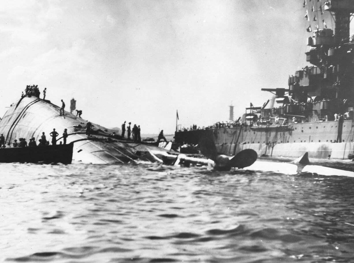 The capsized USS Oklahoma (BB37) and the USS Maryland (BB46) after the Japanese attack on Pearl Harbor, 1941.