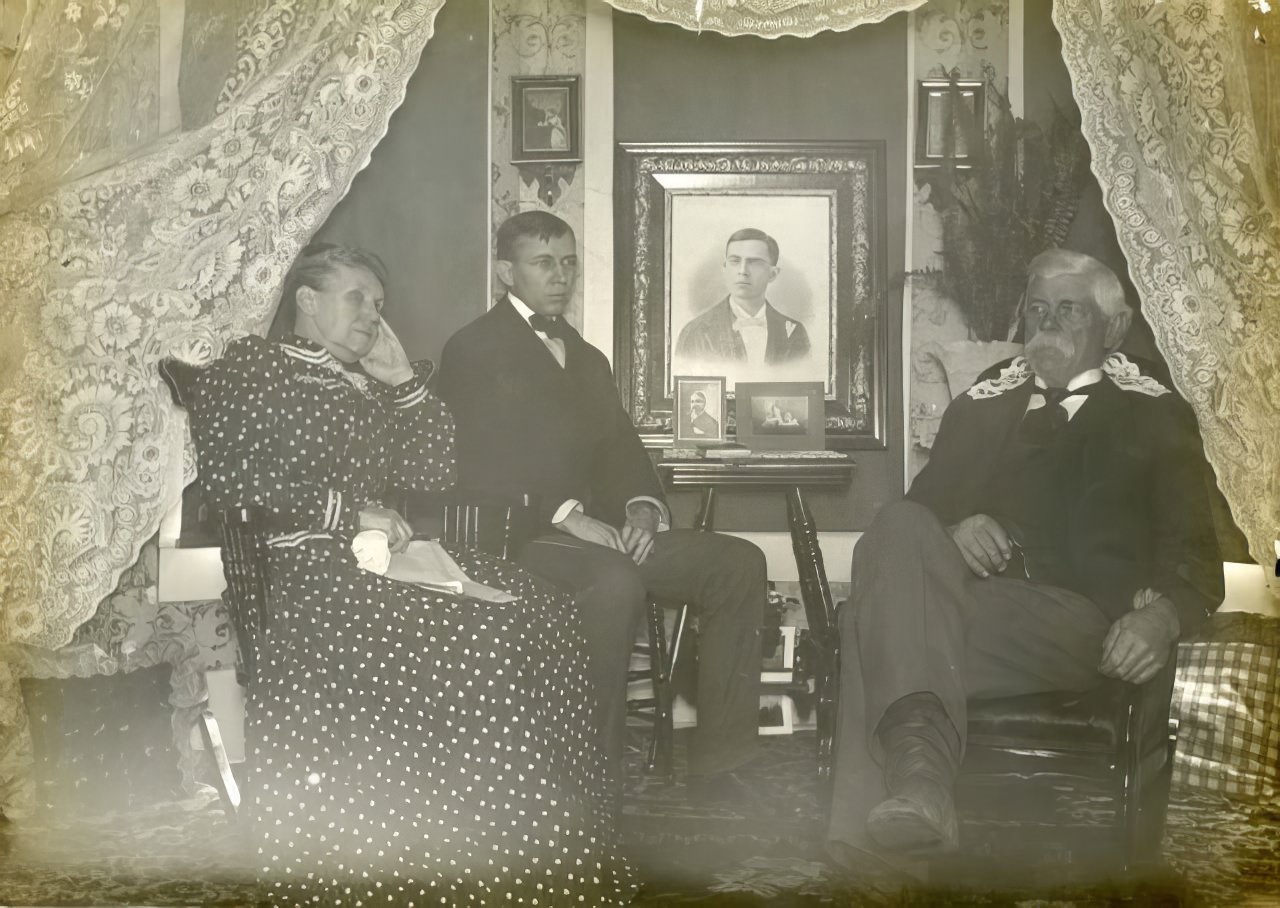 Family seated in front of lace curtain