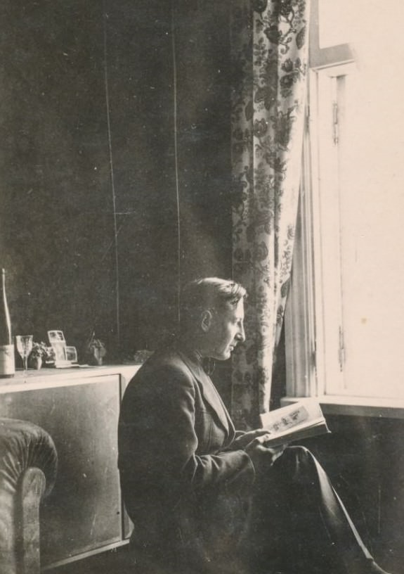 Man reading a book by the window