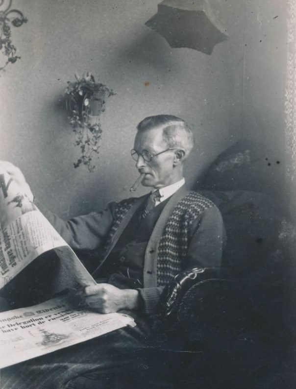 Old Danish man reading the paper and smoking a cigar