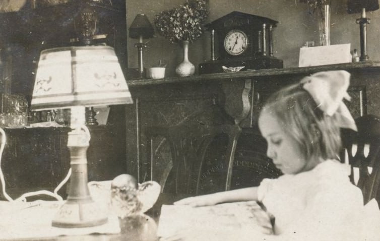 Little girl reading at a table