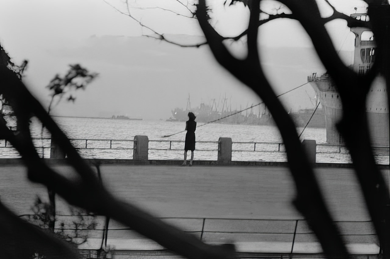 Yoko sometimes goes down to the port in Yokohama to watch the ships sail off to the places she only wishes she cold go. At sunset, her 'day' begins again, 1964.