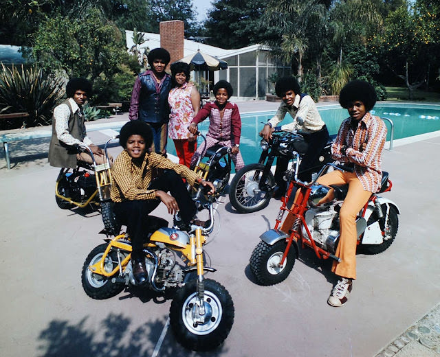 The Jackson 5 with their parents standing by, 13-year-old dynamo Michael (front left) and his brothers Jackie, Marlon, Tito and Jermaine straddle their motorbikes by the pool, 1970.