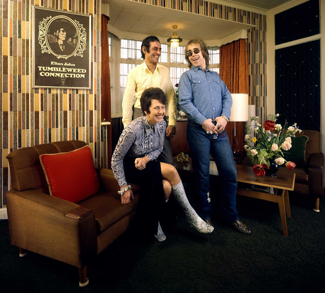The former Reggie Dwight, later known as Elton John, laughs with his mom Sheila Fairebrother and her husband Fred (whom he affectionately called "Derf," Fred spelled backwards) in their suburban London apartment in 1970.