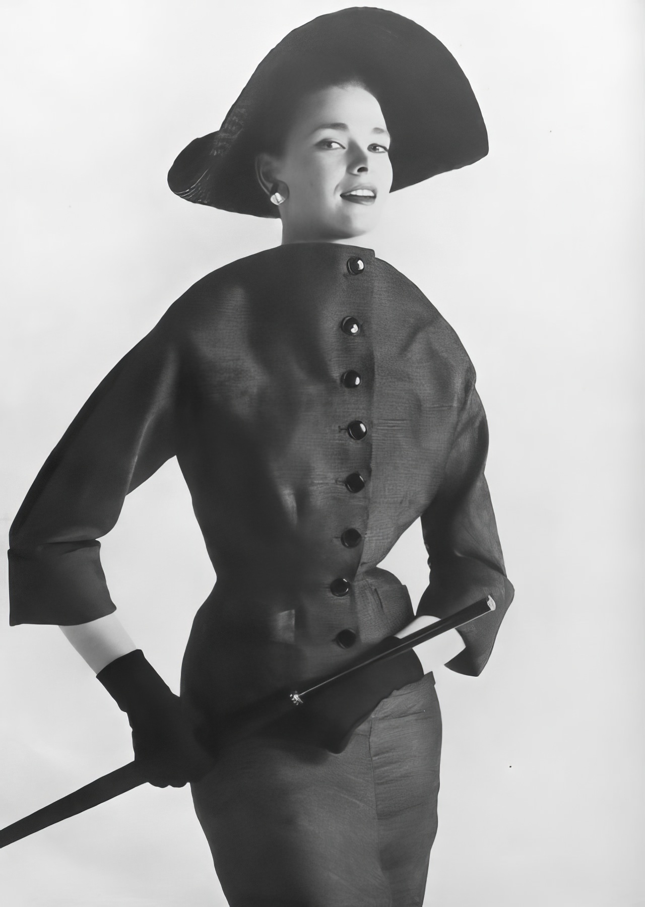Susan Abraham in a grayish-olive green suit, 1953.