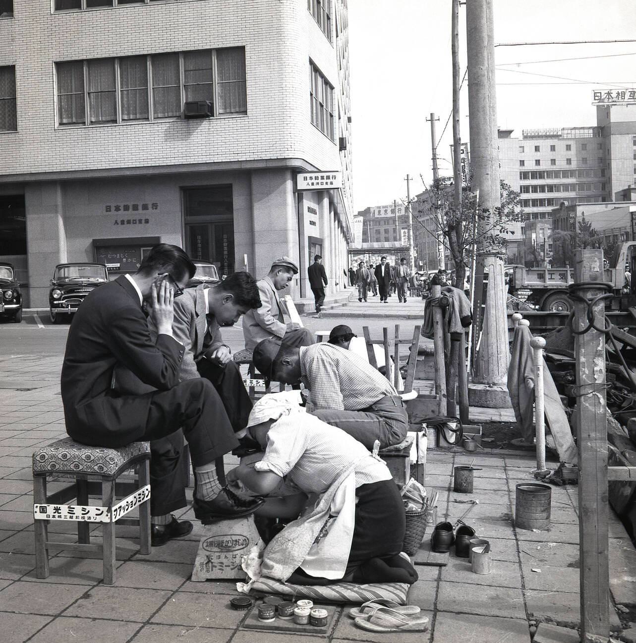 Japanese businessmen having their shoes cleaned and polished, 1950s.