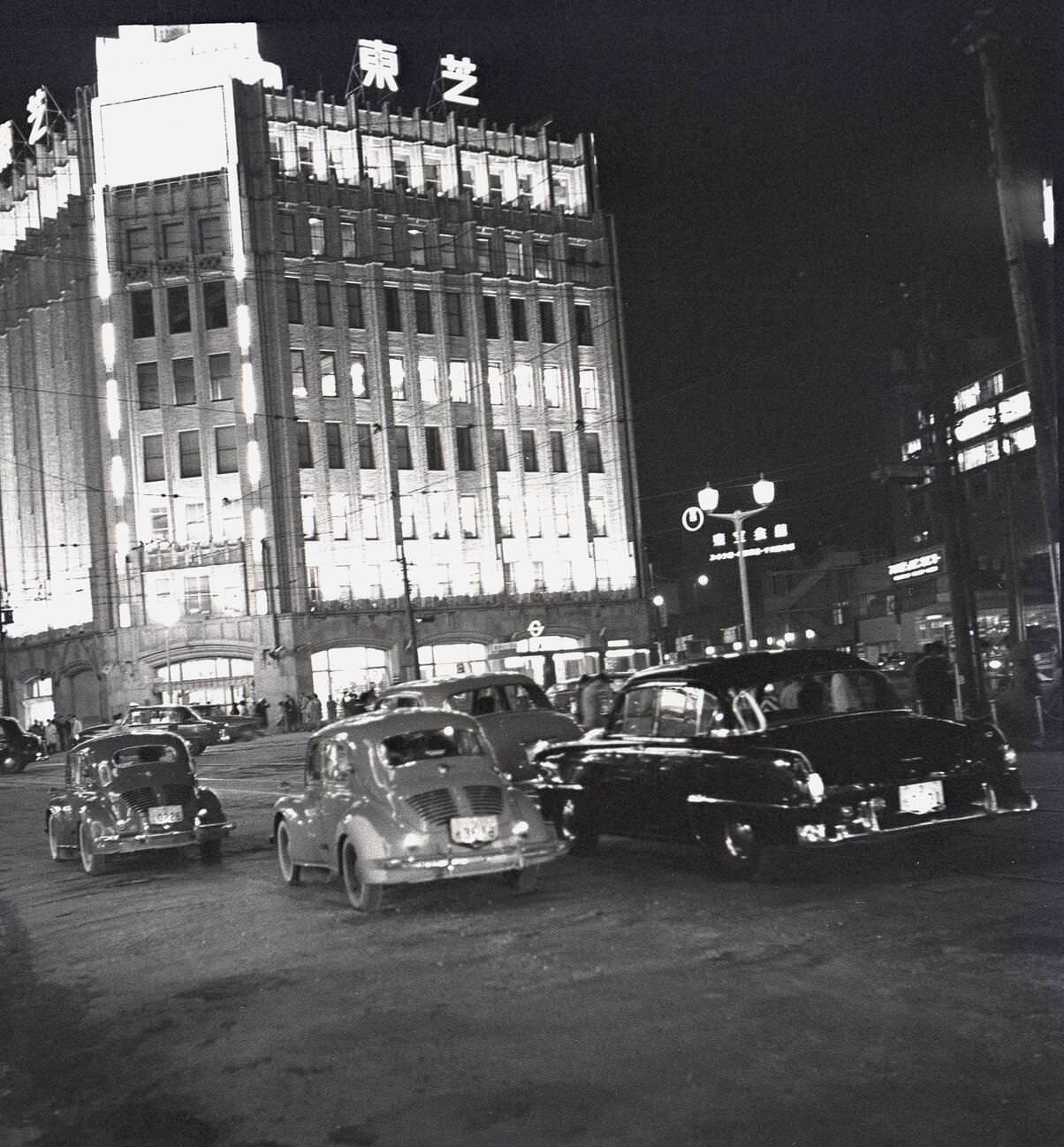 Evening time in Tokyo, lit up buildings and motorcars, 1950s.