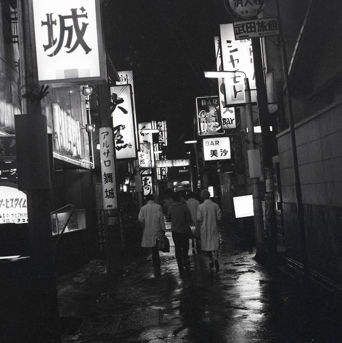 A backstreet of Tokyo where the neon signs of the many bars and restaurants light up the city at night, 1950s.
