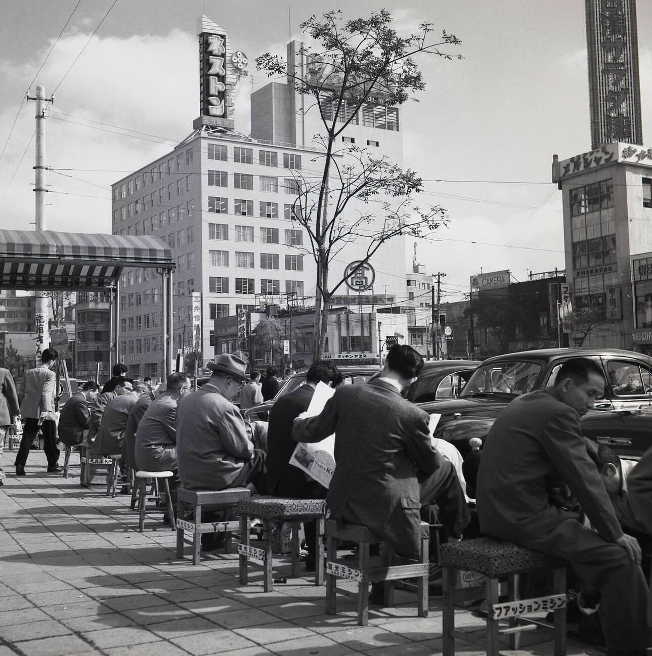 A row of shoe shining stands outside, 1950s.