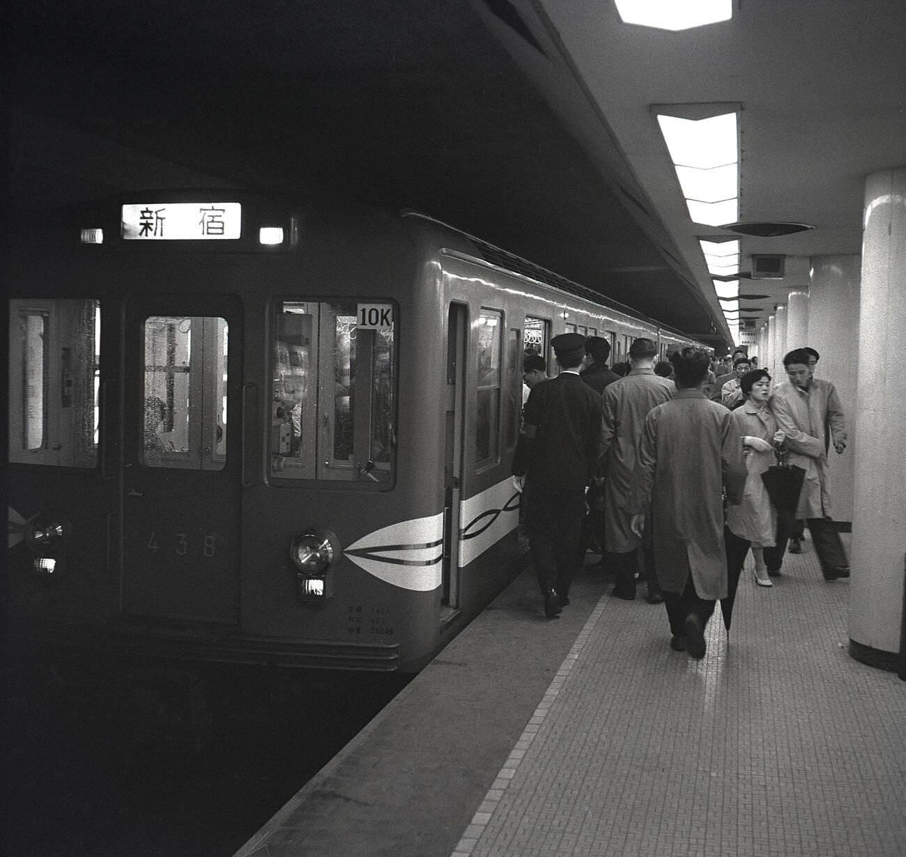 Japanese commuters boarding a metro train in Tokyo, 1950s.