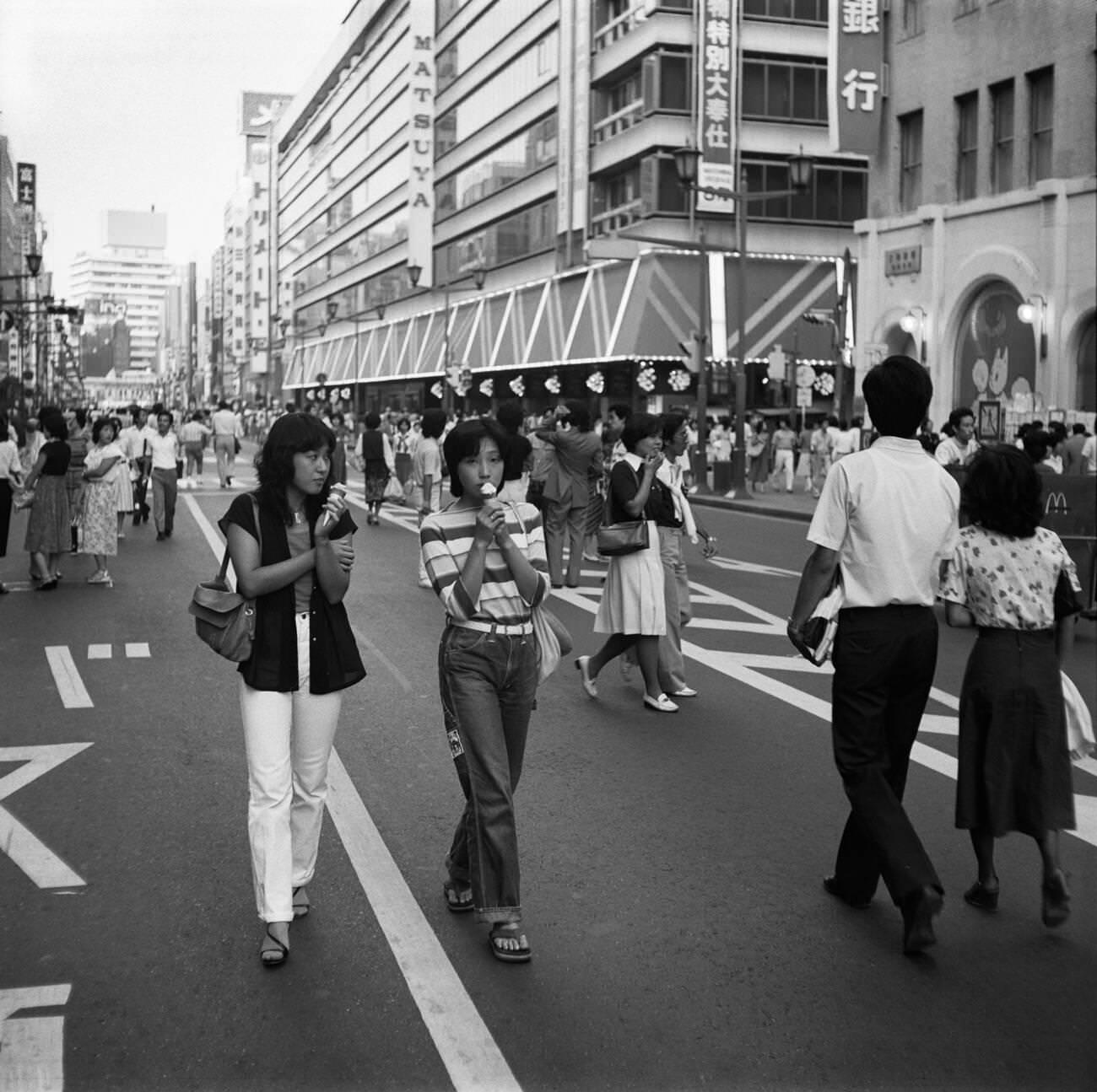 Young women with ice cream walk down the street, Tokyo, 1978.