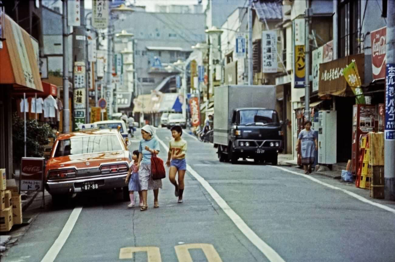 A woman with two children crosses the street in Tokyo, 1970s.