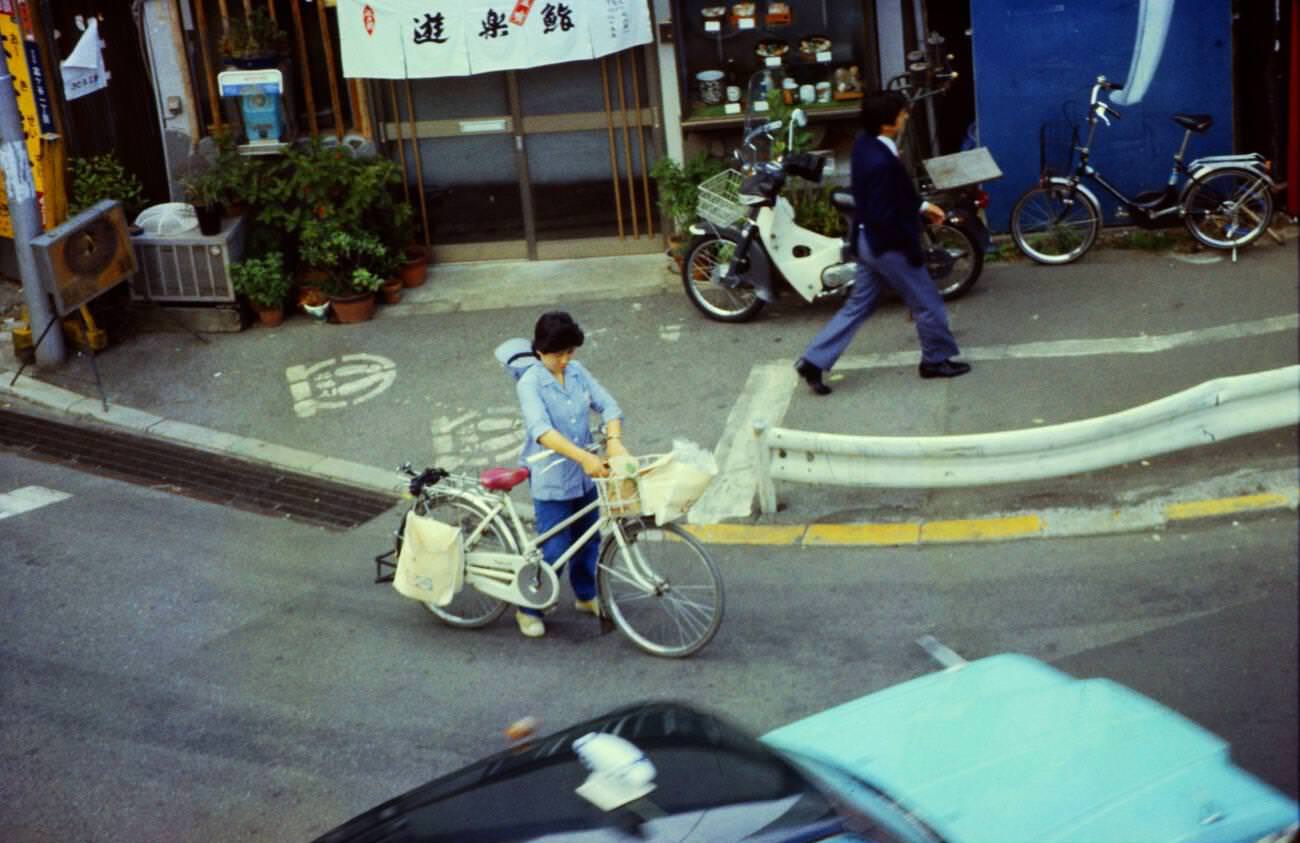 Woman with a bike and shopping on the street, Tokyo, 1970s.