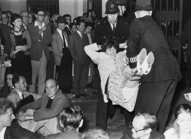 A demonstrator lets himself go limp as police officers carry him from Trafalgar Square, London, United Kingdom, to a waiting van during the mass ban-the-bomb rally, 1961.