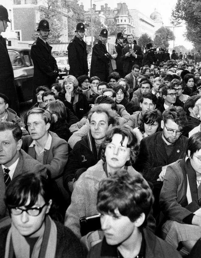 Police line Bayswater Road in London, alongside squatting ban-the-bomb demonstrators near the Soviet embassy, 1961.