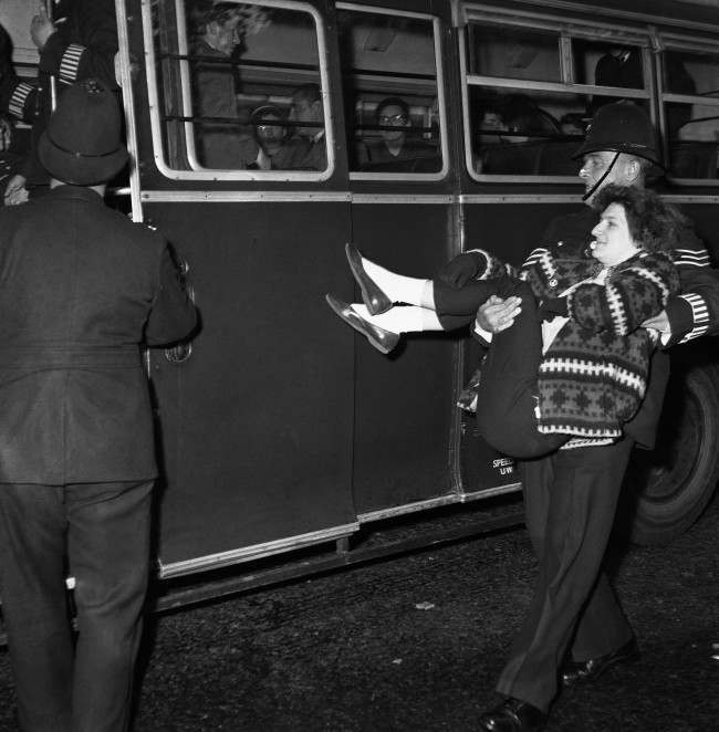 A girl ban-the-bomb demonstrator is carried to a waiting van by a policeman in Bayswater Road in the vicinity of the Soviet Embassy in London, United Kingdom, 1961.