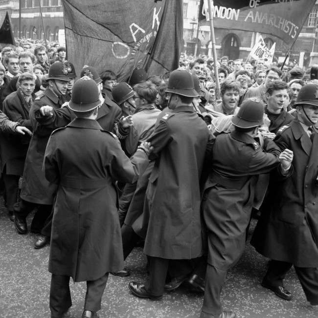 Police straining against a solid mass of people in an effort to control a contingent of Aldermaston to London marchers as they made their way to the final rally in Hyde Park, 1963.