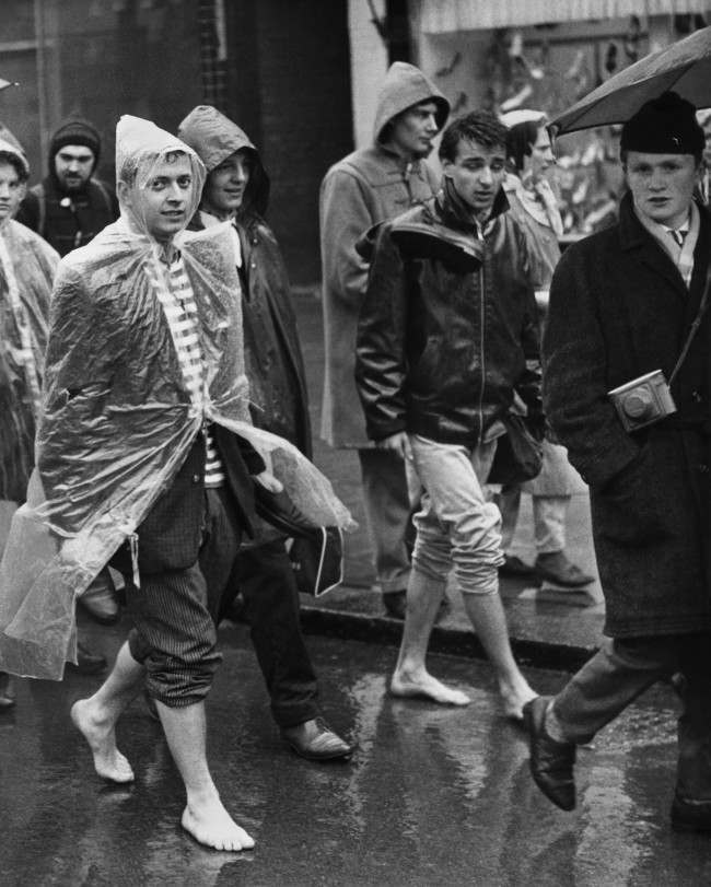 A couple of barefooted youths with trousers rolled up trudge through Cheswick, west London, in the rain as the Aldermaston column of "Ban-the-bomb" marchers set off on the last weary lap of their long trek to Trafalgar Square, 1961.