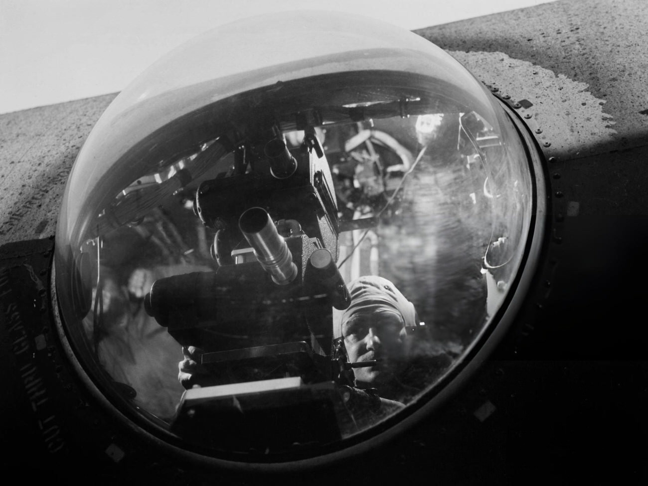 American Army photographer Charles T Forsythe, protected by the blister as he aims his dual high-speed camera during a Joint Army-Navy Task Force demonstration in a B-29 Bomber, at Roswell Army Air Field in Roswell, New Mexico, 1946.