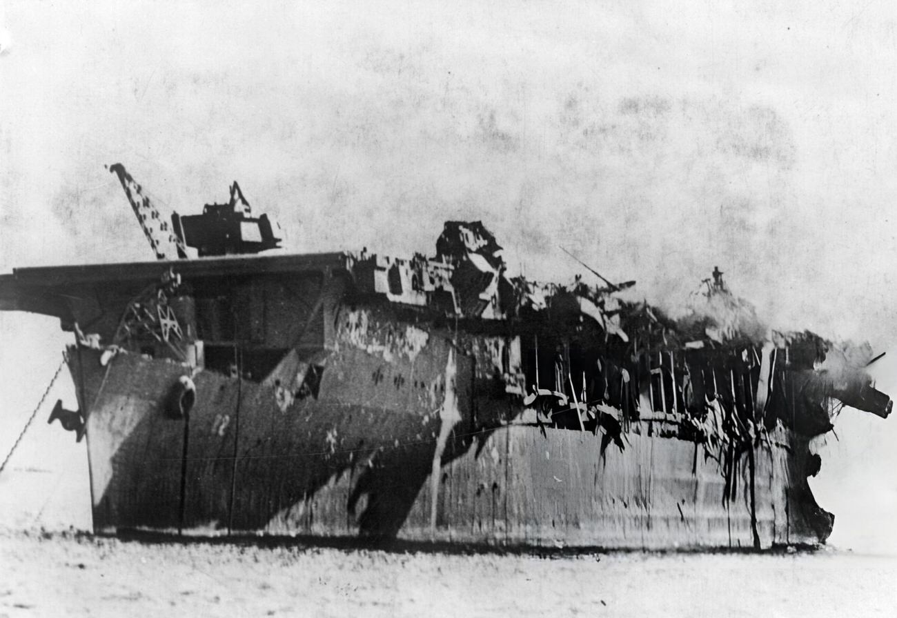 The remains of the light carrier the USS Independence, burning but still afloat, following America's atomic bomb test in Bikini Lagoon, 1946.