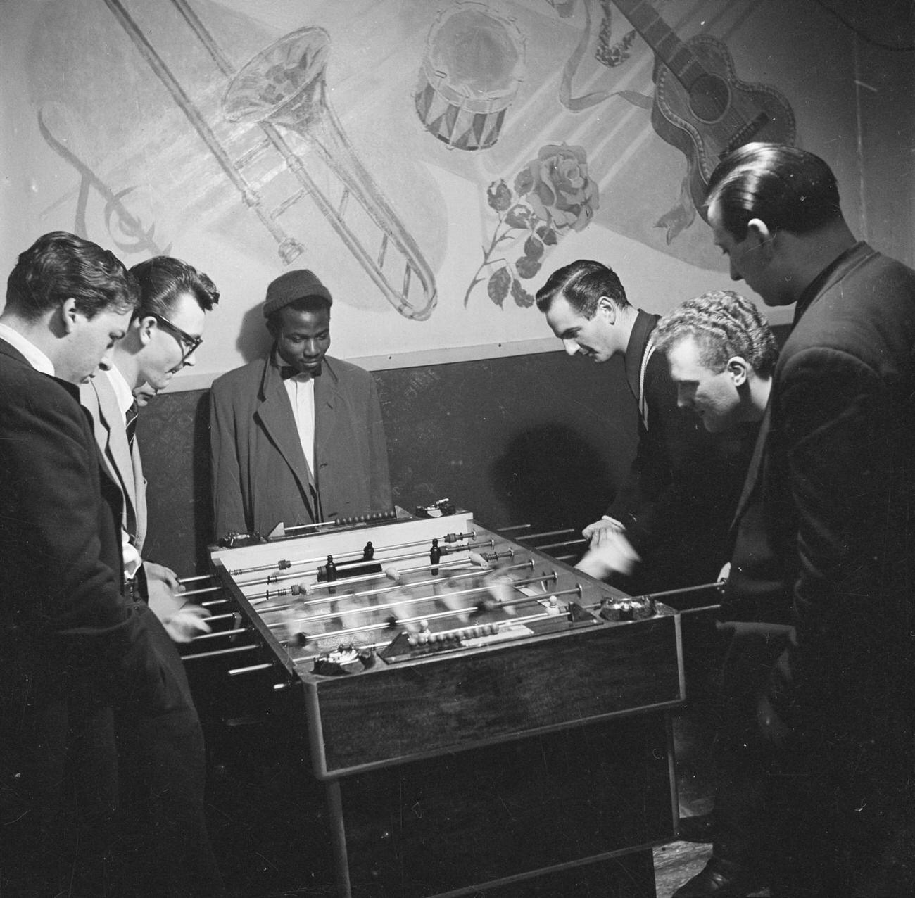 Photograph of jazz musicians playing table football, including Ronnie Scott, Benny Green, Derek Humble and Pete King by Nigel Henderson 1954