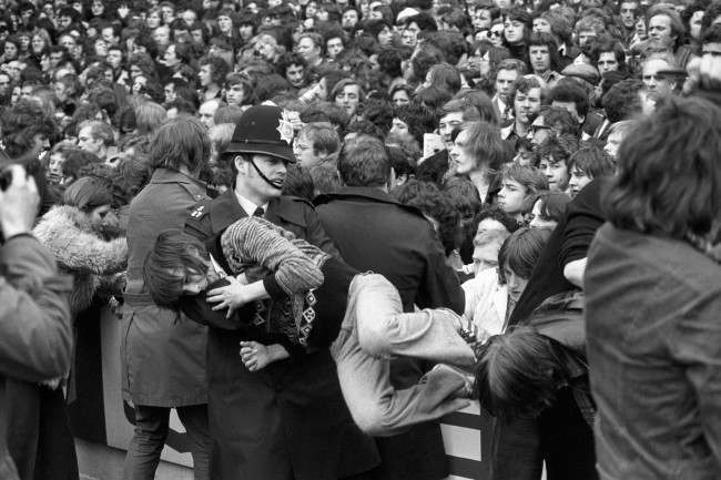 A young fan is carried away by a policeman after trouble erupted before the match, 1970s.