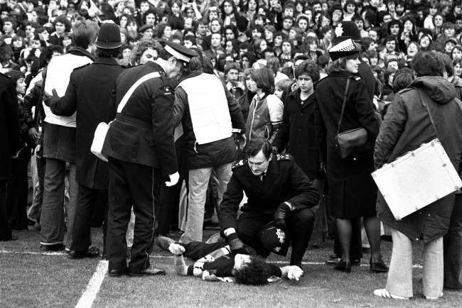 First aid for a young fan after crowd trouble broke out, 1970s.