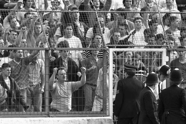 Chelsea fans hurl abuse at police officers, 1980s.