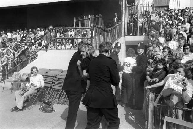 Two policemen remove a football supporter from Highbury, 1970s.