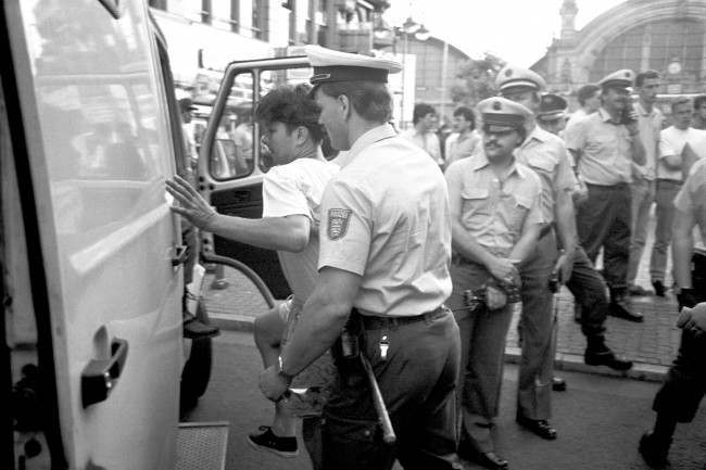 An England fan is loaded into the back of a police van, 1980s.