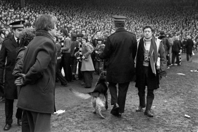 A policeman herds the Newcastle United fans back onto the terraces after they invaded the pitch, 1970s.