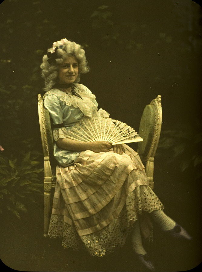 Young lady with fan on a couch, 1910