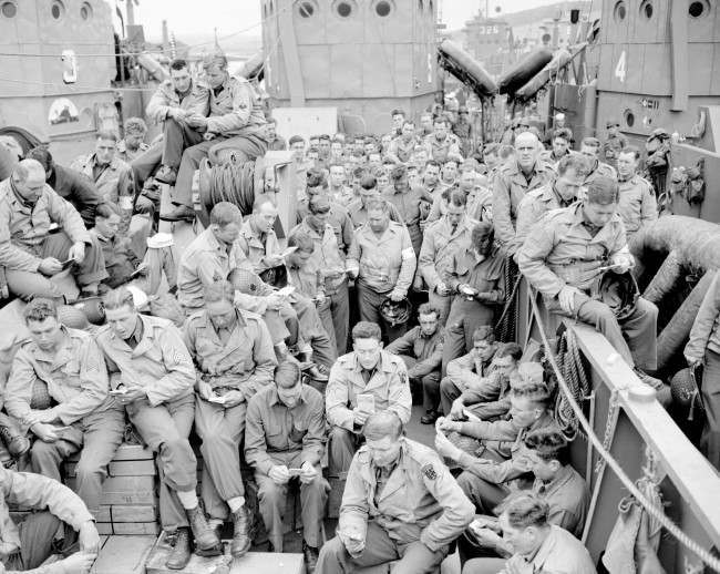 U.S. serviceman attend a Protestant service aboard a landing craft, 1944.