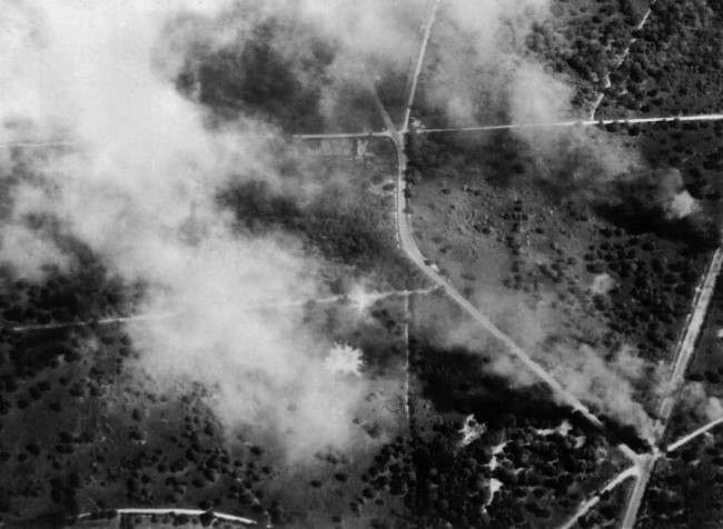 Wrecked enemy vehicles burning on one of the roads after attacks by aircraft in Normandy, 1944.