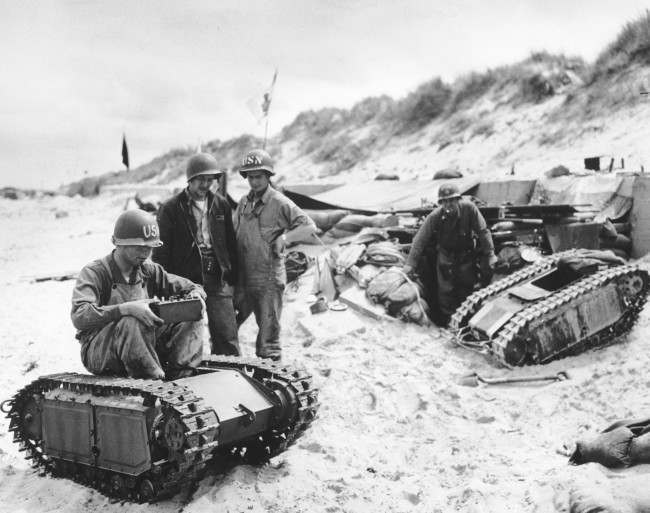 U.S. Navy men take apart a German “Beetle”, a miniature tank loaded with explosives, during the Allied Normandy landings in France, 1944.