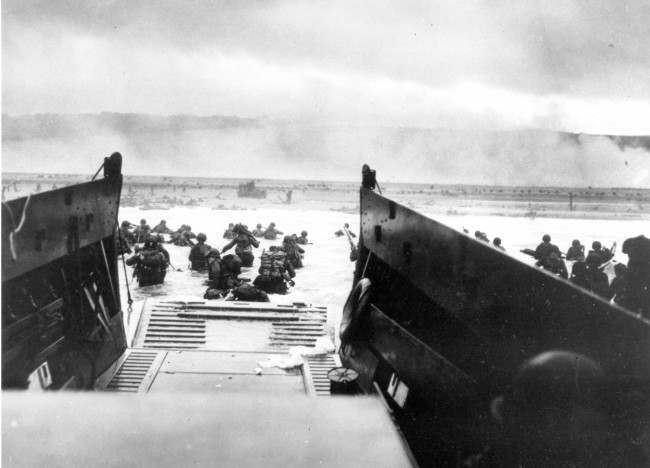 Under heavy German machine gun fire, American infantrymen wade ashore, 1944.