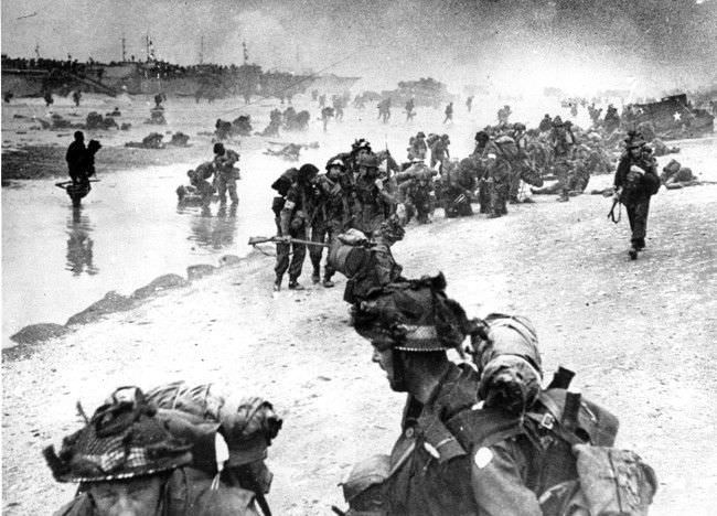 British troops move on the Normandy shore from their landing craft, 1944.