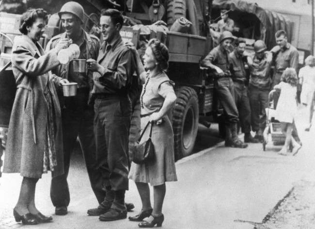 British women pour tea for American soldiers heading for the south coast of England, 1944.