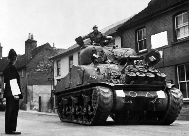 A British Army Sherman Tank rumbles down a street on its way to a south coast port, 1944.